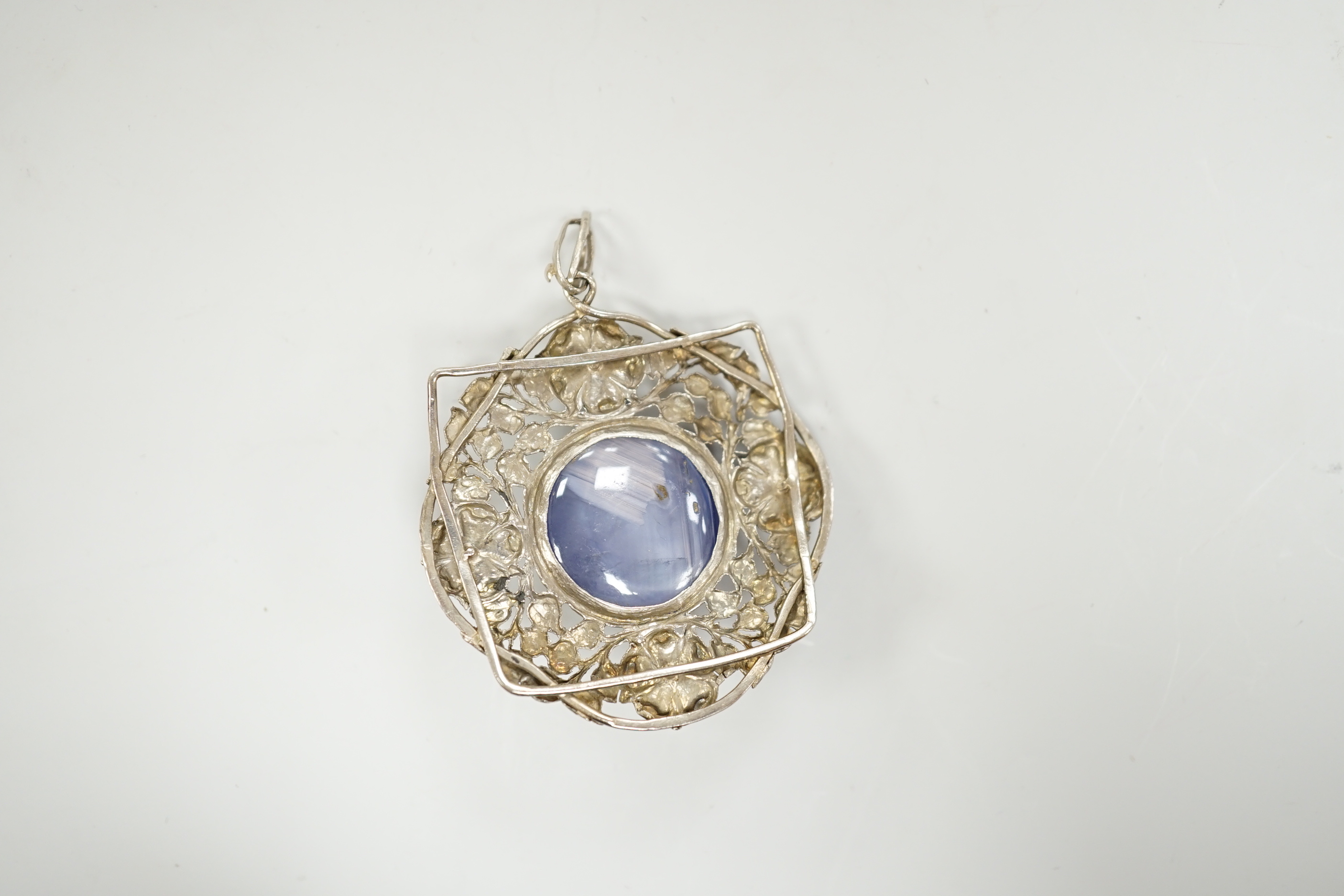 An early 20th century continental pierced white metal, cabochon star sapphire and cultured pearl set circular pendant, diameter 46mm.